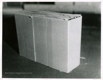 A box of flat glass cased in cardboard frame before loaded in wooden frame case.