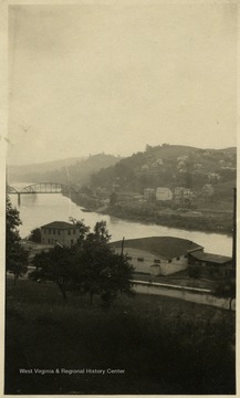 The steel bridge to Westover is in background. The West Virginia University campus in the foreground, including the old fieldhouse called the "Ark", which is the white building with a curved roof.