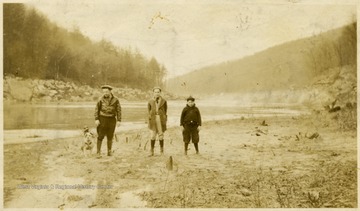 'Sir site of Joe McDermotts cottage on the Mt. Chateau Lodge slide, being raised then C.P. Pride, Dick Pride, and Jack Hare, and Doc at the left'Doc, at far left, was the firehouse dog of the Morgantown Fire Department.