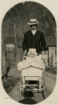 'Dr. Ladwig and his daughter, Cornelia. Dr Ladwig is pushing the pram, something few men did then, especially in a lumber or mining town. This say something about the man.'