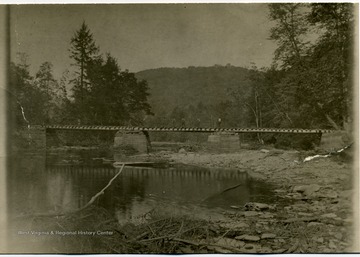 'The above is a private railroad bridge of M. M. &amp; D. D. Brown located just below the mouth of Little Black Fork, which was put in to go up Black Fork to get timber in that valley as well as to switch up the east bank of the Cheat River to get the timber between Little Black Fork and Rattle Snake Run. We were obliged to build a submarine bridge across Cheat River below the Stone House and go across the Old Taylor farm on the west side of the river to Little Black Fork and then cross on property where we had the right of way in order to save the Elkins Rail &amp; Lumber Company from paying an unreasonable charge of $ 10,000 for crossing a wedge shape piece of land near the mouth of Rattle Snake in order to save the Rail Company from paying this money we spent approximately $3,500, most of which was an extra charge as we could have gotten what timber we had on the west side between Rattle Snake and Black Fork with either a temporary railroad or by skidding to the river and pulling across the river with the loader or skidder. The Rail Company was obliged to furnish the right of way on the east side river according to an agreement they had made with us; however, we wouldn't' permit them to be unreasonably held up, consequently, the crossing of the river ans recrossing at the mouth of Black Fork. The Black Fork Bridge was a hard one to maintain as it was at the mouth of Little Black Fork stream and we were bothered with a heavy current that washed the piers badly. Although, we maintained it through the life of the operation. It was later replaced with a more modern bridge by the U. S. Monongahela Forest.'