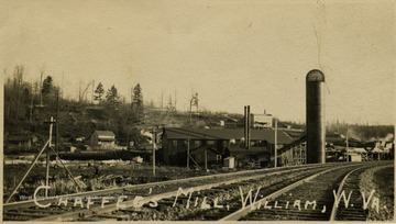 Postcard photograph of a view from the railroad tracks of the lumber mill. See the original image for correspondence on the back regarding family illness.