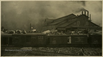 Postcard photograph, several railroad box cars belonging to the Pennsylvania Anchor Line, in the foreground.