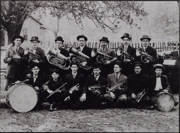 A group portrait of musicians posed holding their instruments. 