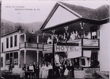 Large group posed in the front of the hotel and on the balcony.