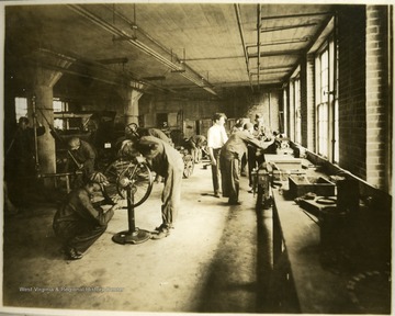This portrait shows a general view of part of the laboratory showing men at work.