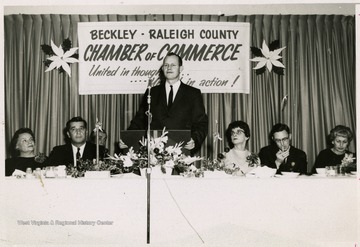 From "Beckley U.S.A." by Harlow Warren, p. 522, Vol. 2. In book: "L to r: Mr. and Mrs. Burl Sawyers, State Road Com.; Alex George, Master of Ceremonies; New President, Rodney L. Webb, addressing annual (Dec. 1961) dinner at Beckley Hotel; Mrs. Gene Morehouse, Mr. Gene Morehouse, Outgoing President; Mrs. Cecil L. Miller, wife of Mayor Cecil L. Miller" (p. 522).