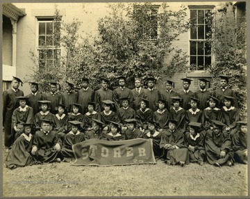 Group shot of Storer College class of 1923 in front of building and tree.