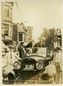 Davis riding through the streets of Clarksburg, W. Va. John C. Johnson in car.