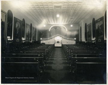 Distant view of decorations used in special communion service at Andrews Methodist Church. Notice large oil paintings on walls.