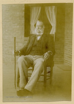 Portrait of John Thomas Gibson sitting on the front porch of his Charles Town, W. Va. home. Mr. Gibson is sitting in his father's (James Gibson) chair.