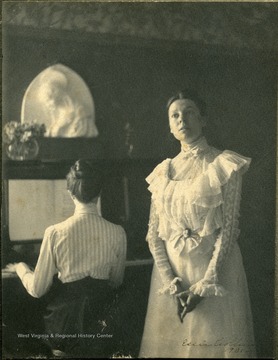 Annie Jones is singing, Zan Gibson is playing the piano. Prize won for photography listed on back of the photograph: "Moscow, Berlin, Calcutta, American Photography, 1901"