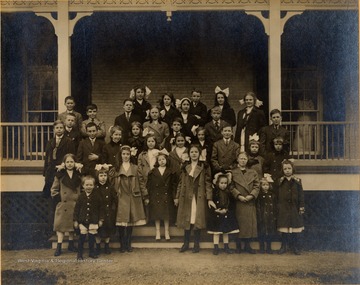 Children posing on outside steps of a building. The two girls standing in front row, center, are probably Margaret H. Gibson and Frances D. Packette