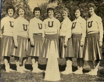 Group portrait of unidentified members of the University High Cheerleaders in uniform. A megaphone sits in front, labeled "Hilltoppers". 