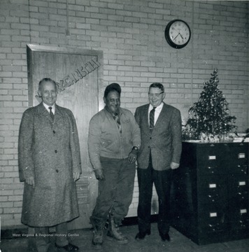 Photograph taken at Christmas time. Standing far left is Elmer Prince. 