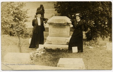 Maria and Ella Haldeman aside the grave stone of husband and father, Thomas Haldeman. 