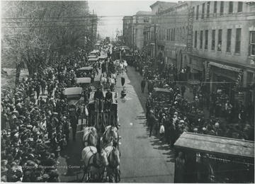 Townspeople line the street in Beckley, West Virginia to watch horse carriages.