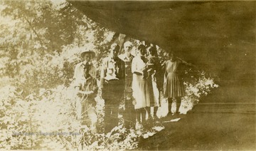 The Carpenter family poses at the cave entrance. Inscription on the back of the photograph, "Where first white child (Solomon Carpenter) was born".