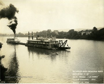 "C.B. Harris", a pipe line dredge, being trailed by a stream powered towboat. The "Harris" was built by The Charles Ward Engineering Works in Charleston, West Virginia.