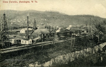 Postcard photograph of an elevated view of the glass factories and oil derricks in Mannington, West Virginia. See original for note written on the back of postcard.