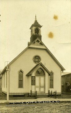 Postcard photograph of wooden church with beautiful trim on the bell tower located in St. Marys, the county seat of Pleasants County, West Virginia.