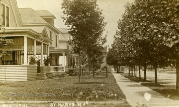 Postcard photograph of a tree lined street and several houses with large front porches in  of St. Marys, county seat of Pleasants County, West Virginia.