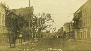 Postcard photograph of unpaved Main Street in Spencer, West Virginia.