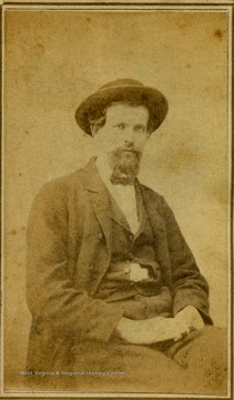 A carte de visite portrait of an unidentified bearded man wearing a hat. There is a revenue stamp on the back of photograph indicating a tax had been paid on the image. This tax was collected, 1864 to 1866 by the Federal government to pay for the war.