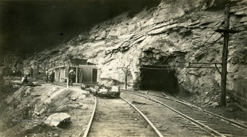 Railroad tracks run into and around the mine opening.