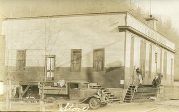 Side view of Coal Company Store with unidentified individuals outside and a ca. 1930 pick-up truck parked next to the store.