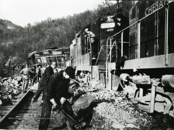 Unidentified men work to salvage track and train after a wreck in Fayette County. Other information on the back of the photograph includes: "Hinton Daily News Coll. from Fred Long to Stephen D. Trail Su Co WV 8-26-1996".
