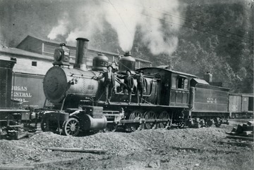 Three employees standing on the C&amp;O locomotive are, left to right: W. L. Buck, engineer; G. L. McShartney, engineer; Hamm Bobbitt, fireman.