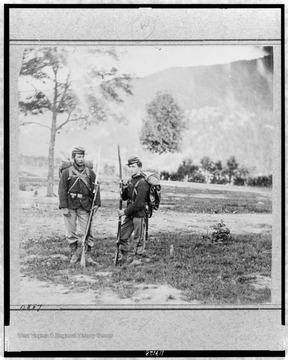 Two unidentified Union soldiers in uniform, full pack and armed on Camp Hill above Harpers Ferry during the Federal forces occupation of the area early in the Civil War. Note the huge bayonets attached to their rifles.