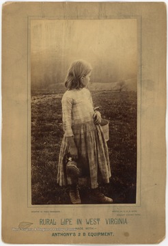Unidentified girl with a bucket on her arm, looks toward the open fields. The print at the bottom of the photograph includes, "Made with Anthony's 2 B Equipment." and "Printed with N. P. A. Extra brilliant Albumen Paper".