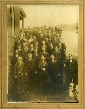 Portrait of the Hinton YMCA, taken outside on porch steps. The man with the beard is John R. Mott and the man in the 2nd row, 1st from right is G. K. Roper. All others are not identified. The photograph was given to Stephen Trail by Melvin Plumley. 