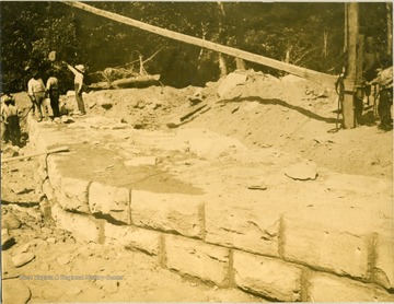 Unidentified workers building an abutment for a railroad bridge.