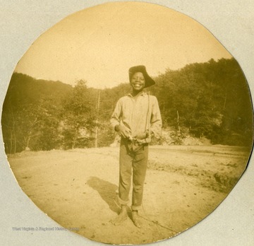 Unidentified African-American youth happily poses, taken during the construction of the Ohio extension of the Norfolk &amp; Western Railroad.