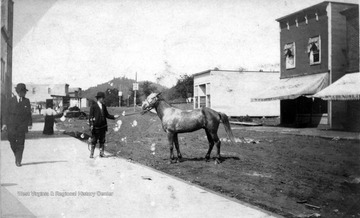 Unidentified man shows a horse on a dirt road in downtown Gassaway.