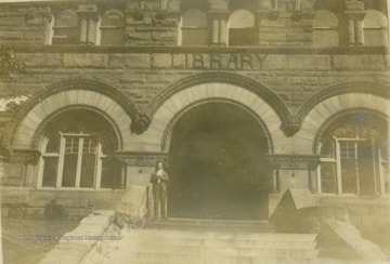 Unidentified man standing on the steps of Stewart Hall. Built in 1902, Stewart Hall was originally the University library.