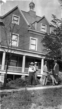 Boggs Hospital and Sanitarium was located on Braxton Street. Identified are:  Gay Rusmisell (2nd from left) and Dr. C. C. Rusmisell holding the dog. This building became a Y.M.C.A. (Young Men's Christian Association) and was later torn down.