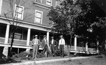 Left to right: 1. Gay Rusmisell; 2. Dr. C. C. Rusmisell; Other subjects are not identified. This building became a Y.M.C.A. before being torn down.