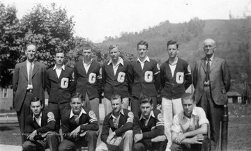 Several young men wearing Lettermen's sweaters, possibly a sports team or organization. Back Row, L to R: unidentified; unidentified; Hitchock; Ralph Warner; unidentified; unidentified; unidentified. Front row: left to right: Bill Brown, unidentified; unidentified; unidentified; Cogarion. 