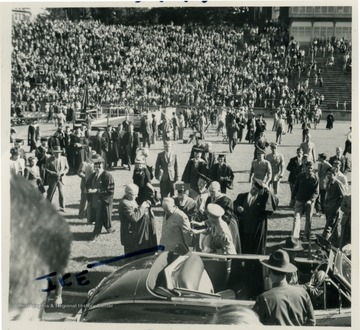 General Dwight D. Eisenhower prepares to address the students and faculty at West Virginia University during a special convocation at Mountaineer Field. General Eisenhower is standing on the far side of the vehicle, wearing a light colored uniform. Others in this photograph are not identified.