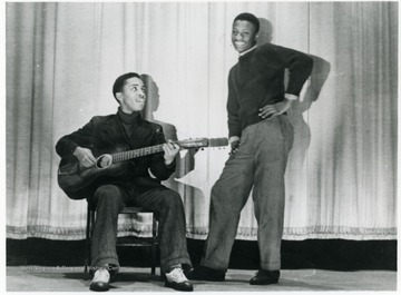 Bill Younger and an unidentified young man performing a duet on stage. Information on p. 128 in "Our Monongalia" by Connie Park Rice. Information with the photograph includes "Courtesy of Ivry Moore Williams".
