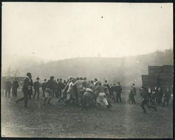 WVU student players gang tackle the ball carrier. All persons are unidentified.   