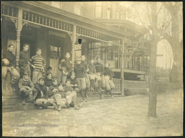Team poses on the front porch of the dormitory. All persons in the photograph are unidentified.