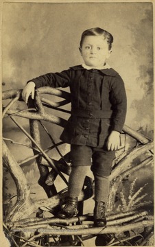A young boy in a jacket and short trousers. 