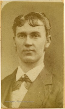 Young man with styled hair wearing a suit and bow tie. 