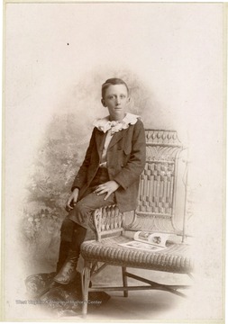 Unidentified young boy in a suit with a very ruffled collar. Large mounted prints such as this are called cabinet cards. 
