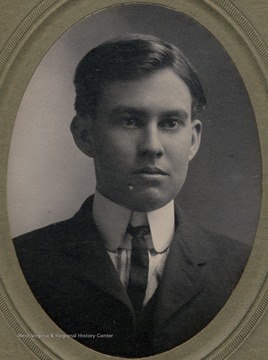 A young man wearing a stiff collar, a suit and tie. 
